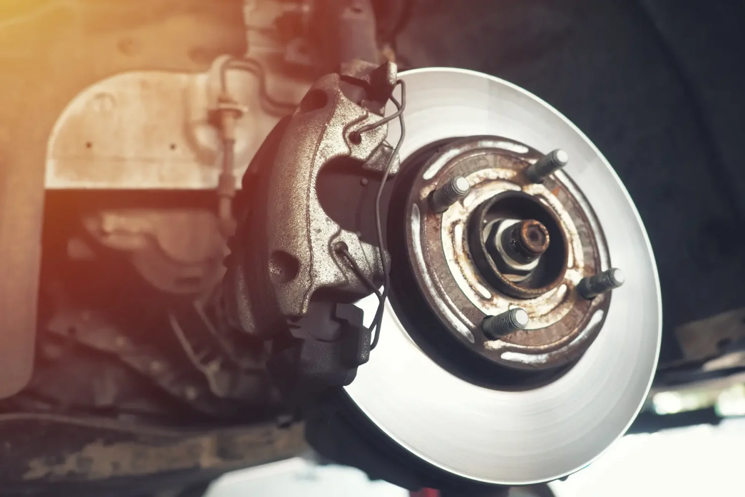 Close-up of a car brake rotor and caliper assembly during maintenance