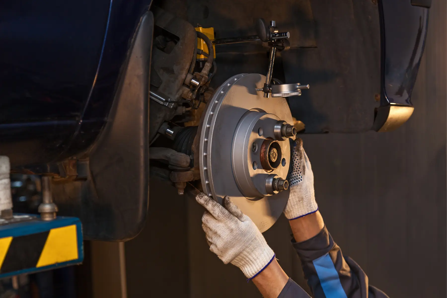 Technician aligning a new brake rotor on a car with precision tools